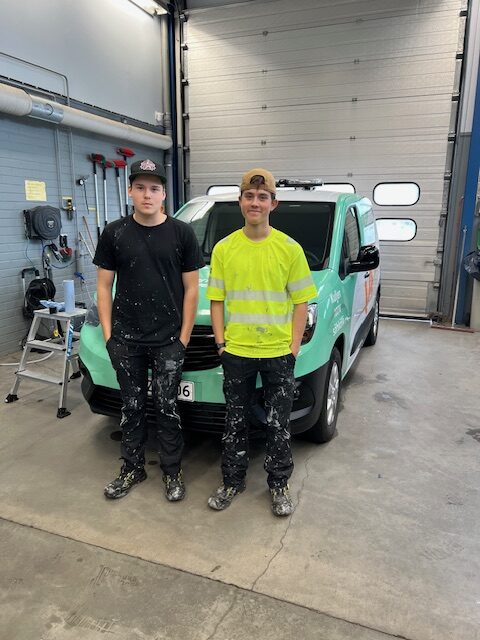 Niilo Kolari ja Akseli Gereli seisovat Varkauden Aluelämmön auton edessä autonpesuhallissa.