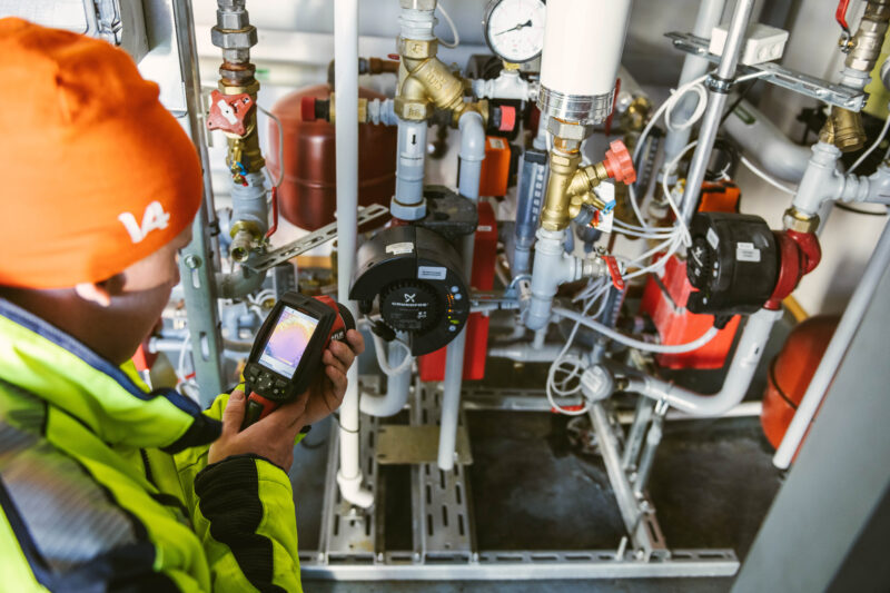 Aluelämmön työntekijä ja omakotitalon kaukolämpökeskus