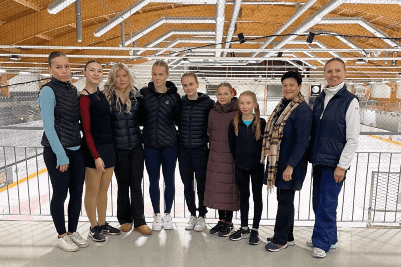 Varkauden Tarmon K1- ja K2-ryhmän seitsemän taitoluistelijaa sekä Olga Baranova ja päävalmentaja Nina Ushakova jäähallissa.